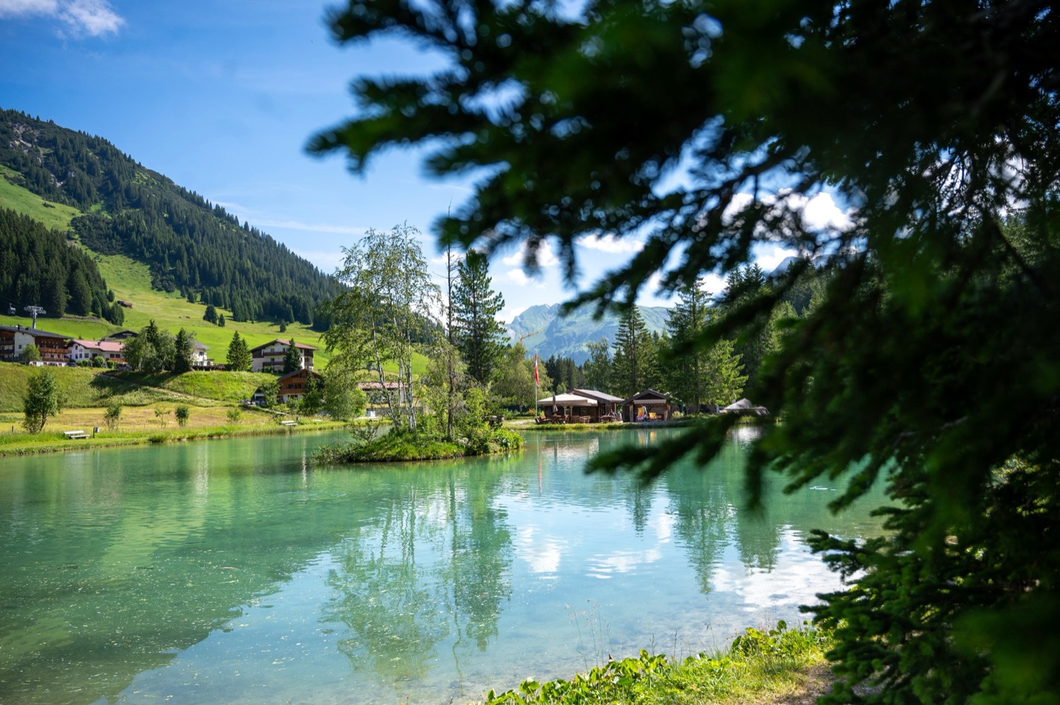 Klarer Bergteich zwischen Fichten mit Blick auf den Fischteich Lech